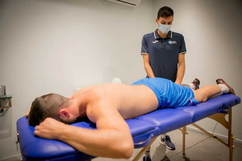 Fisioterapeuta de HVA trabajando con un paciente sobre una camilla.